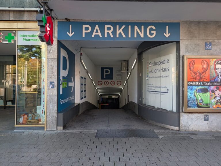 Einfahrt der Tiefgarage am Karlsplatz mit blauem PARKING-Schild